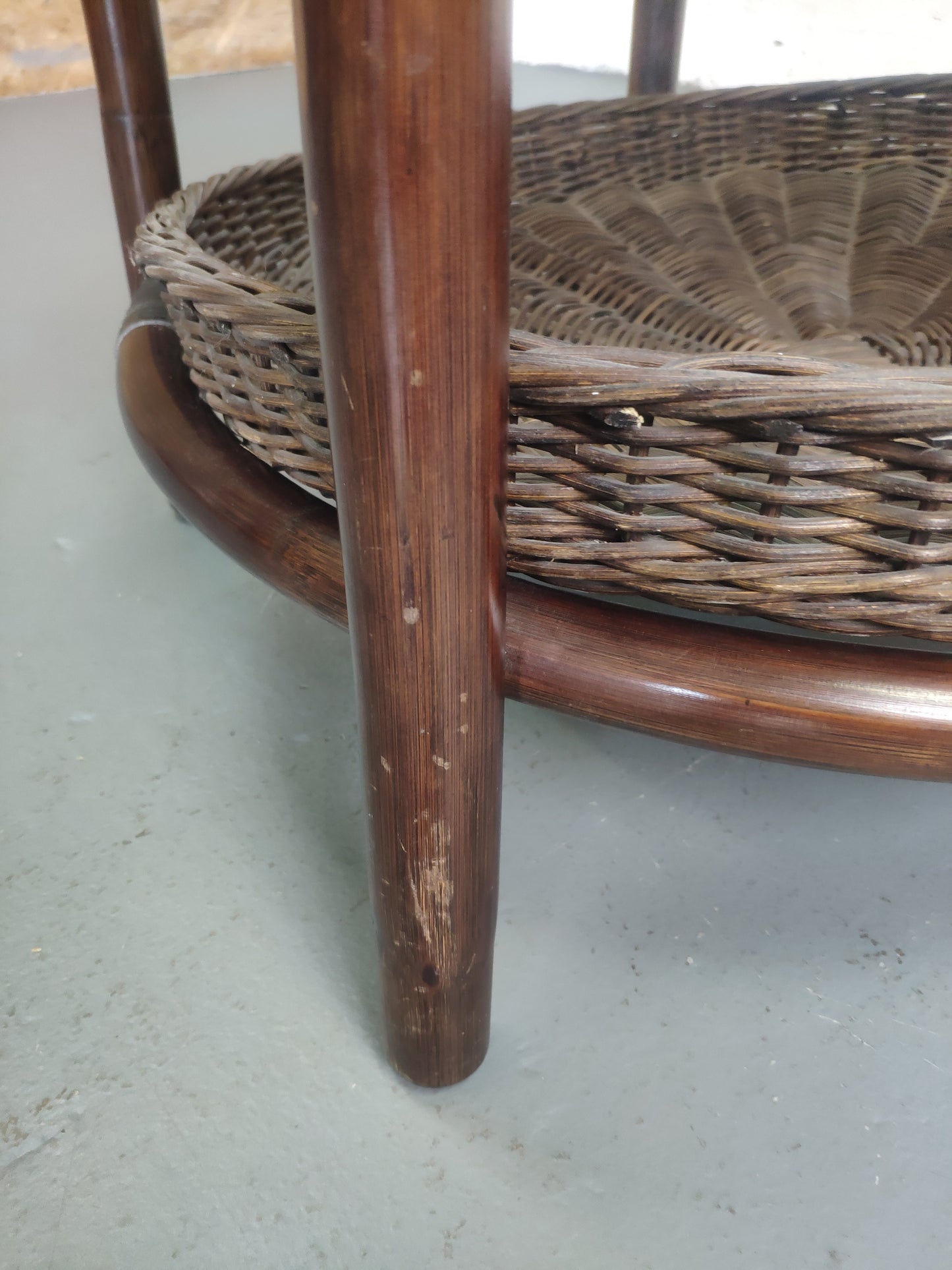 Table basse vintage en rotin avec le plateau en verre fumé et étagère panier en rotin.