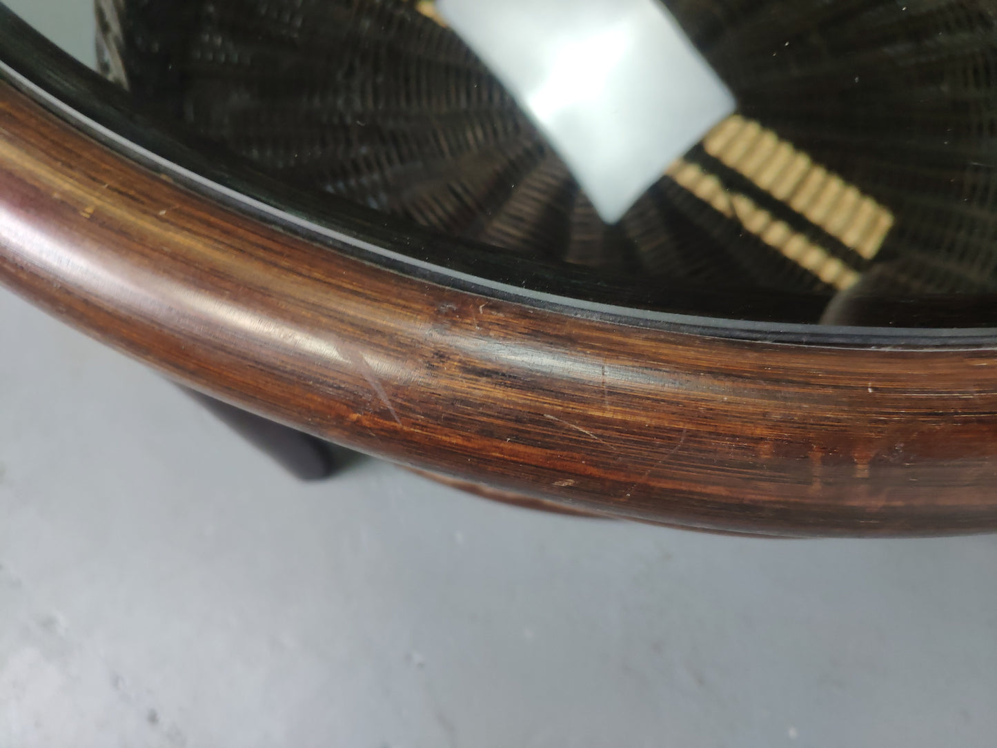 Table basse vintage en rotin avec le plateau en verre fumé et étagère panier en rotin.