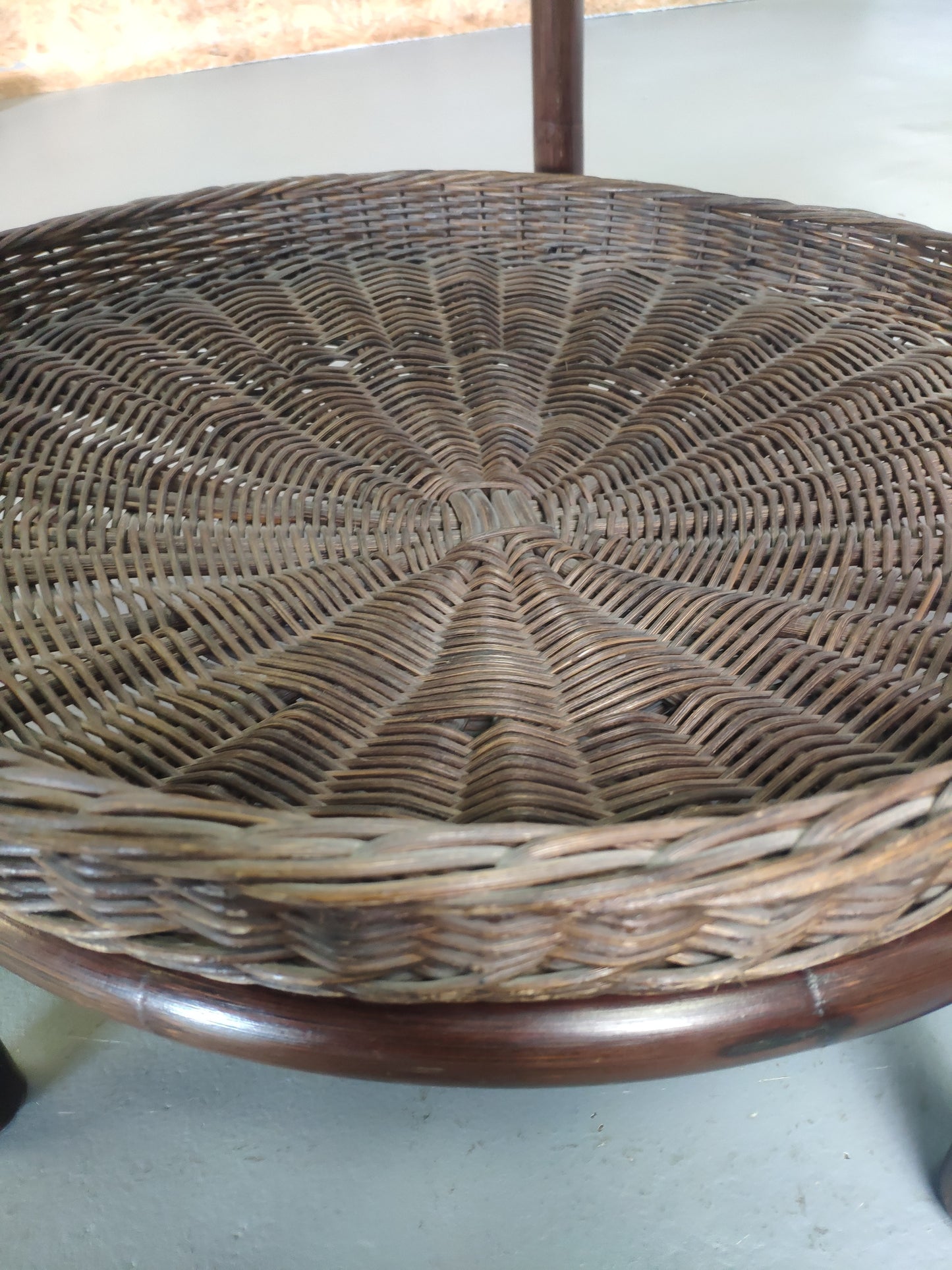 Table basse vintage en rotin avec le plateau en verre fumé et étagère panier en rotin.