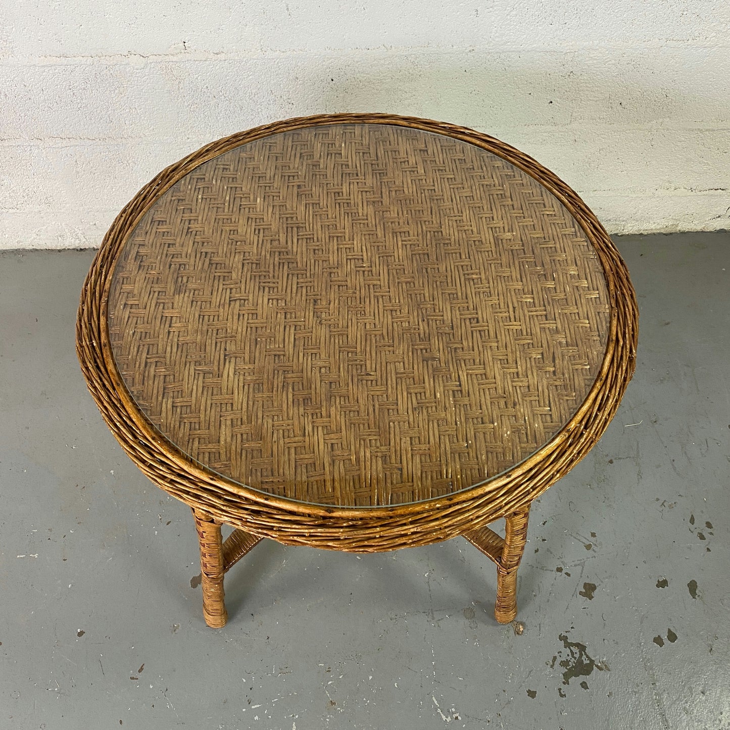 Table ronde en rotin tressé et plateau en verre