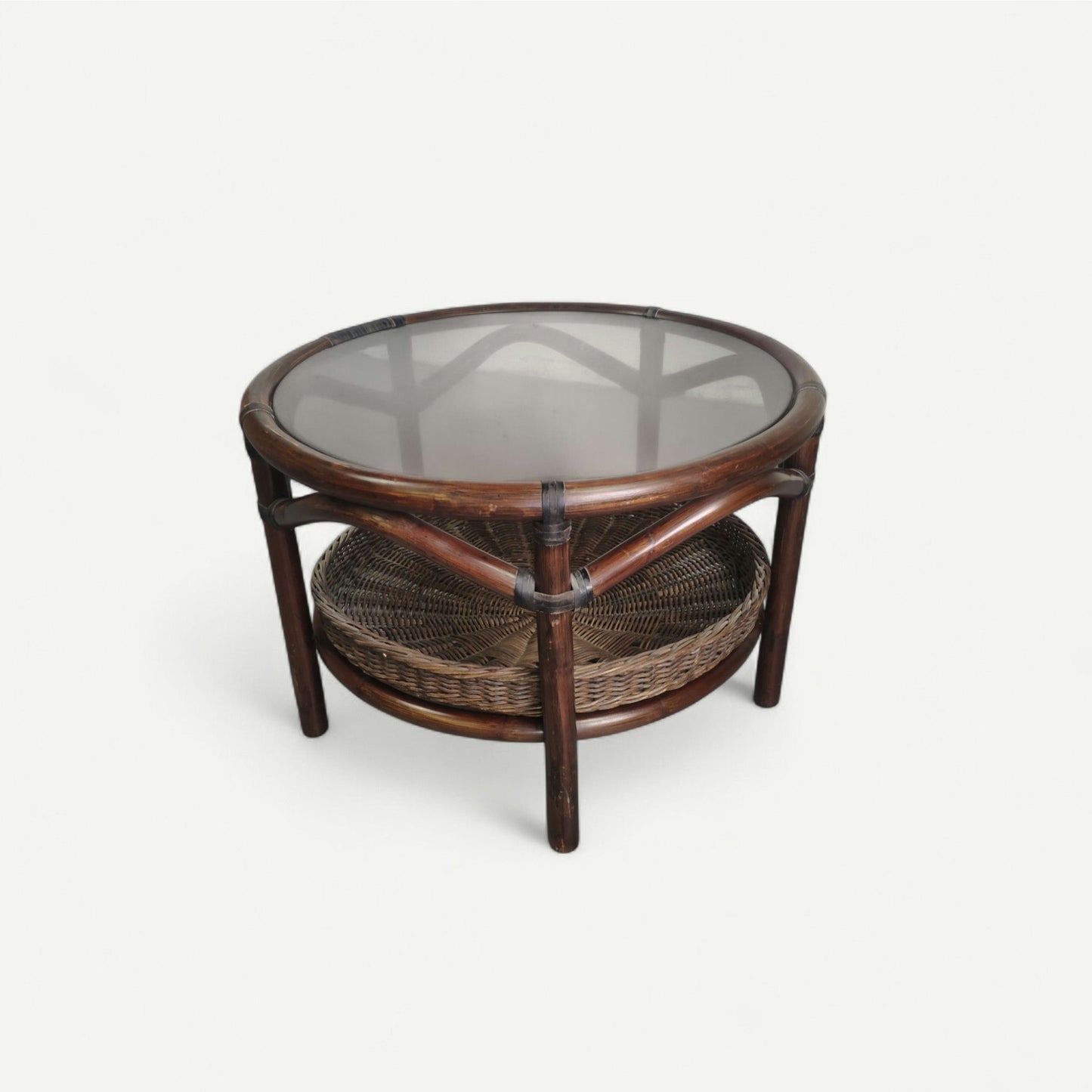 Table basse vintage en rotin avec le plateau en verre fumé et étagère panier en rotin.