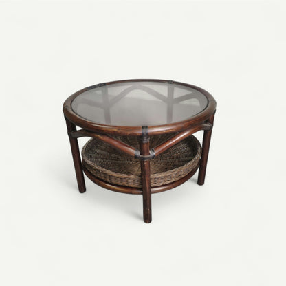 Table basse vintage en rotin avec le plateau en verre fumé et étagère panier en rotin.