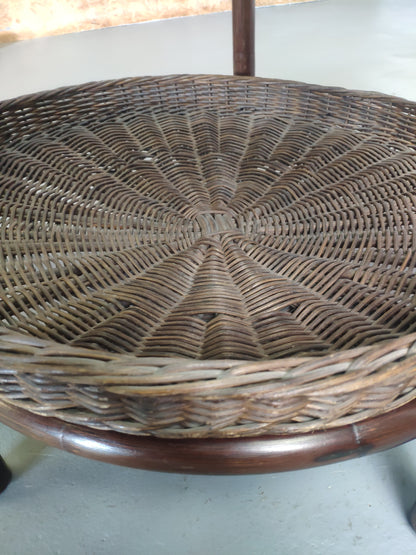 Table basse vintage en rotin avec le plateau en verre fumé et étagère panier en rotin.